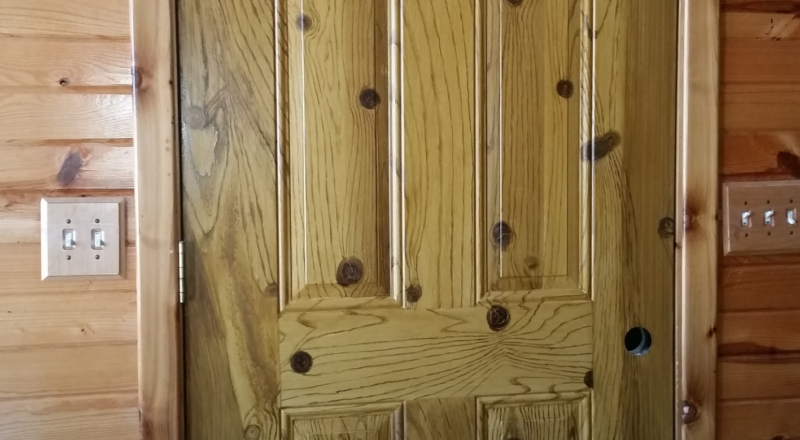 Steel door wood grained in knotty pine